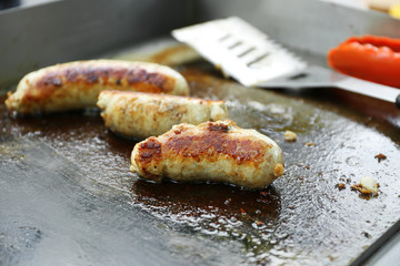 Sausages cooking in frying pan close up