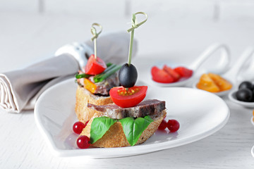 Tasty canapes on wooden table, close up