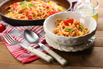 Homemade Spaghetti Bolognese with parmesan cheese in white bowl, on color wooden background