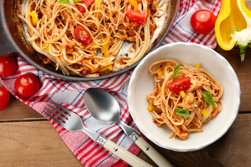 Homemade Spaghetti Bolognese with parmesan cheese in white bowl, on color wooden background