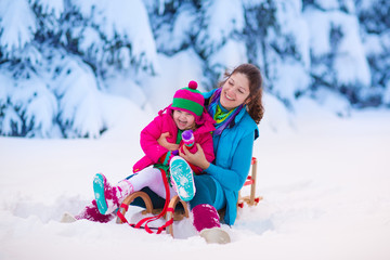 Mother and child sledding in a snowy park