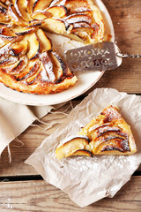 Piece of homemade apple pie on wooden background