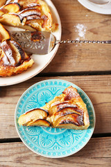 Piece of homemade apple pie on wooden background