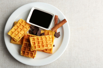 Obraz na płótnie Canvas Sweet homemade waffles on plate, on light background