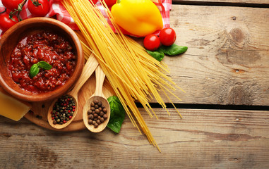 Pasta spaghetti with tomatoes, sauce bolognese, cheese and basil on rustic wooden  background