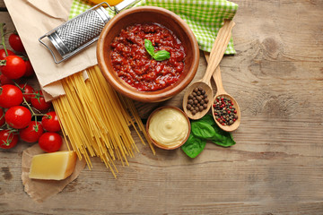 Pasta spaghetti with tomatoes, sauce bolognese, cheese and basil on rustic wooden  background