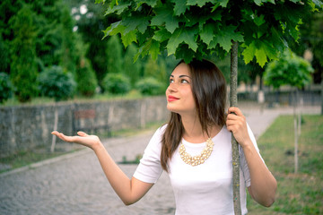 girl hiding from the rain under a tree