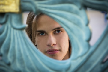 Fototapeta premium Gorgeous Long Hair Man Peeking Through Hole