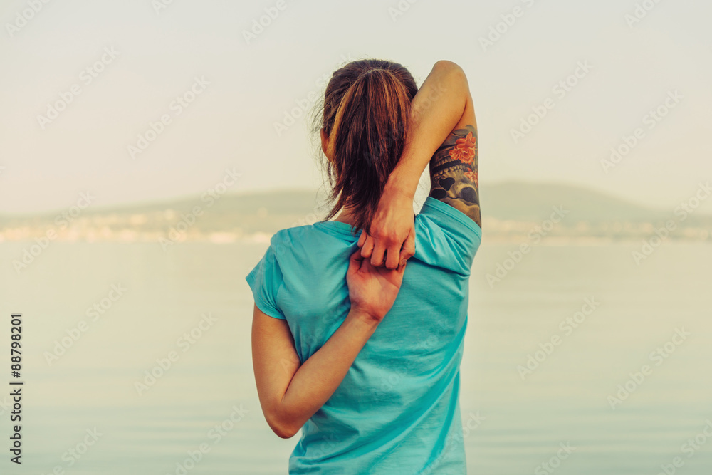 Wall mural Girl warming up her arms outdoor