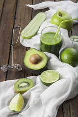 Batido verde o green smoothie con frutas y verduras en la mesa de la cocina para una dieta saludable