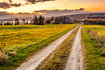 Wooden barn with farmhouse at sunset in Norway