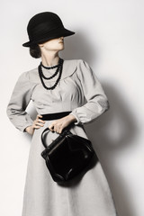 Woman in retro dress and hat with handbag vintage fashion