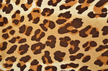 Brown leopard fur pattern. Spotted animal print as background.