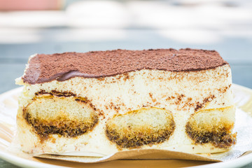 Tiramisu cake on wooden table background