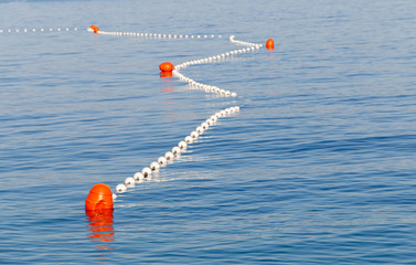 Red markers in the sea marking the safe swimming area © hans_chr
