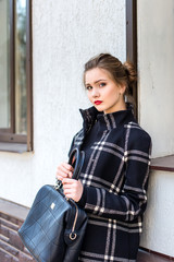 Obraz na płótnie Canvas Young beautiful woman with a fashionable bag is standing on the