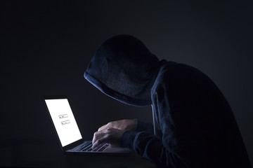 Hacker performing cyber attack on laptop
