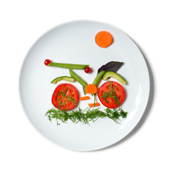 plate with bicycle make of vegetables. vegetarian food.