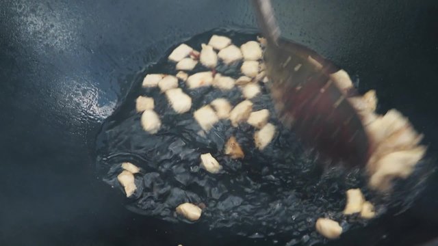 Uzbek national dish pilaf in a large cast-iron cauldron on the fire, the cooking process, fried pieces of fat tail, basis ​​constituting food rice, lamb, carrot, mutton fat, sesame oil, onion, garlic