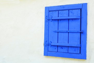 Traditional wooden blue window against white wall