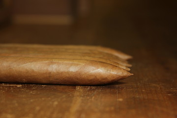four raw pyramid cuban cigars over a table