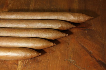 four raw pyramid cuban cigars over a table