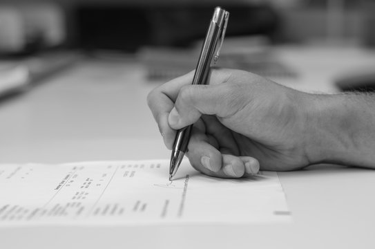 a man hand making the signature on the form