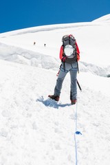 Fototapeta na wymiar Female mountaineer ascending a glacier.