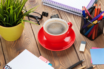 Office table with flower, supplies and coffee cup