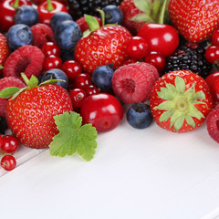 Beeren Früchte mit Erdbeeren, Himbeeren, Kirschen auf Holz