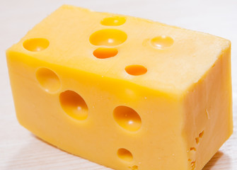 piece of fresh delicious cheese with holes