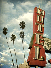 aged and worn vintage photo of motel sign palm trees