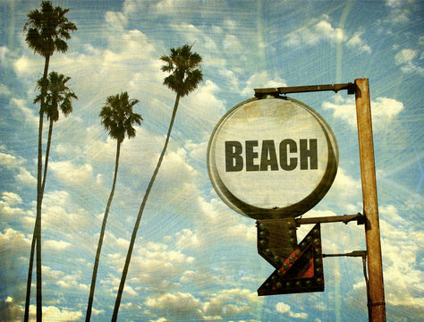aged and worn vintage beach sign with palm trees