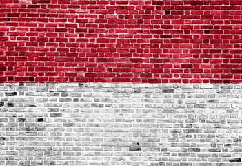 Fototapeta na wymiar Flag of Monaco painted on brick wall, background texture
