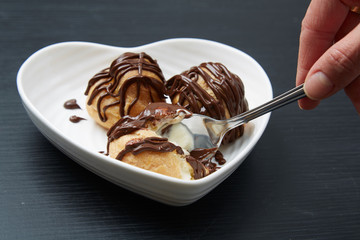 Man Using a Spoon on Bread with Chocolate Syrup