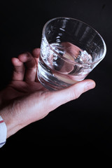 hand holding a clear glass of water