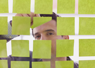 Portrait of a middle eastern business man behind sticky notes in