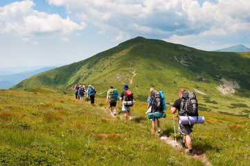 Group of tourists with large backpacks are on mountain