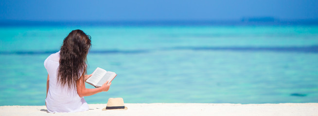 Young woman reading on tropical white beach © travnikovstudio