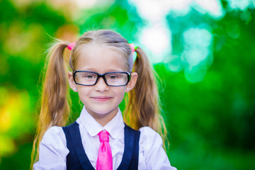 Fototapeta na wymiar Portrait of adorable little school girl in glasses outdoor