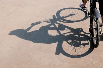 Shadow of the bicycle and the cyclist on an asphalt surface