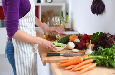 Young woman mixing fresh salad ,oil recharge