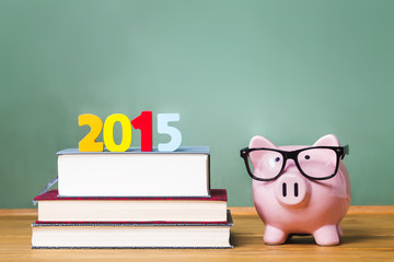 Class of 2015 theme with textbooks and piggy bank with glasses