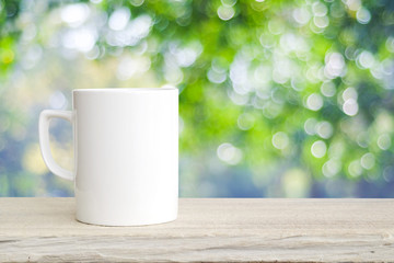 Coffee cup on wood table over blurred tree background