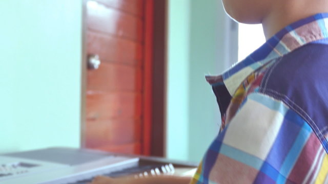 Asian boy playing on electone at home 