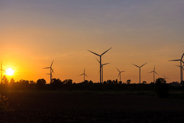 Obraz premium Eco power in wind turbine farm with sunset