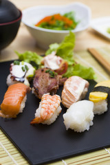 Sushi assortment on black dish, close up