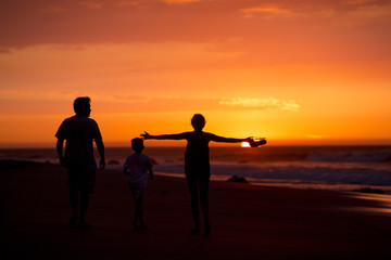 silhouette of family on the beach at dusk in Peru