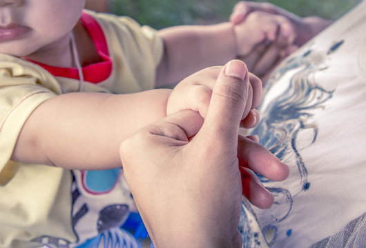 Mom hand holding little boy with love in vintage color filter