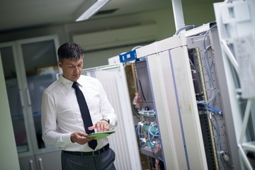 Naklejka na ściany i meble network engineer working in server room